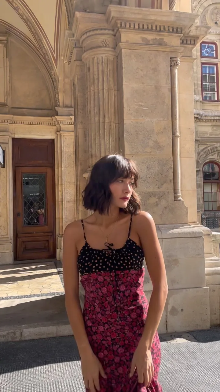 Mimi in a floral slip dress in front of historic Viennese architecture
